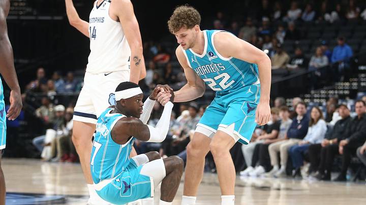 Charlotte Hornets forward Hannes Steinbach (22) helps guard Dennis Schroder (17) up 