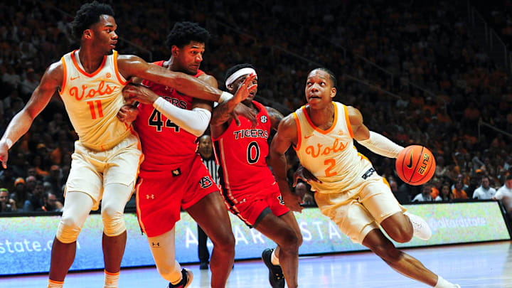 Tennessee guard Jordan Gainey (2) dribbles the ball around Auburn guard K.D. Johnson (0) during a