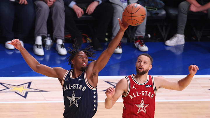 Feb 18, 2024; Indianapolis, Indiana, USA; Eastern Conference guard Tyrese Maxey (0) of the Philadelphia 76ers reaches for a loose ball against Western Conference guard Stephen Curry (30) of the Golden State Warriors during the first quarter in the 73rd NBA All Star game at Gainbridge Fieldhouse. Mandatory Credit: Trevor Ruszkowski-Imagn Images