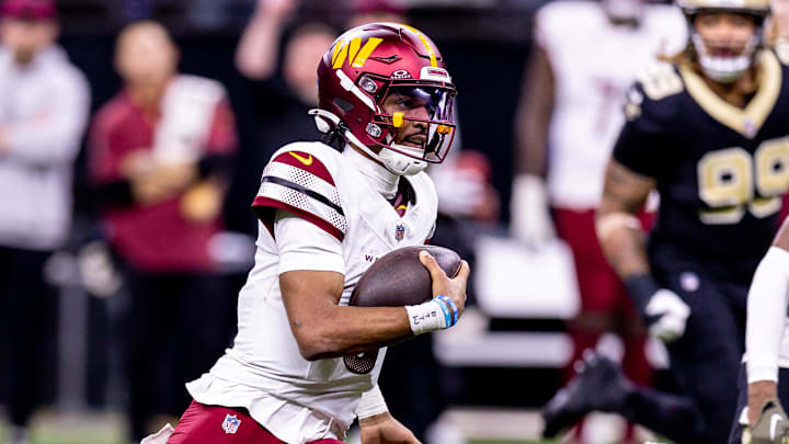 Dec 15, 2024; New Orleans, Louisiana, USA;  Washington Commanders quarterback Jayden Daniels (5) scrambles against the New Orleans Saints during the second half at Caesars Superdome. Mandatory Credit: Stephen Lew-Imagn Images