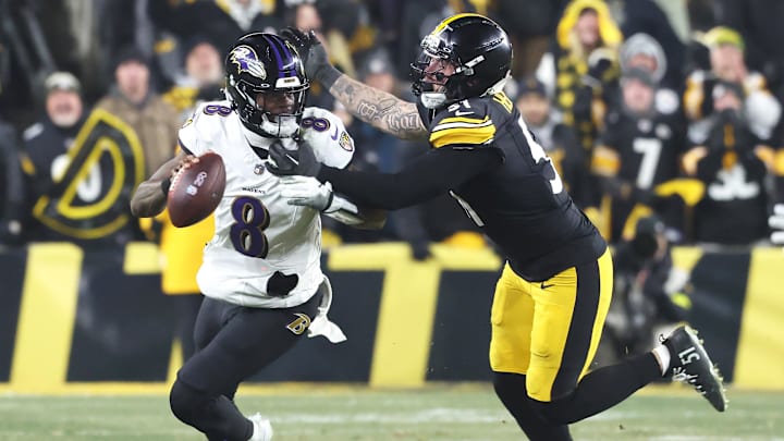 Jan 4, 2026; Pittsburgh, Pennsylvania, USA;  Baltimore Ravens quarterback Lamar Jackson (8) scrambles with the ball as Pittsburgh Steelers linebacker Nick Herbig (51) cases during the fourth quarter at Acrisure Stadium. Mandatory Credit: Charles LeClaire-Imagn Images