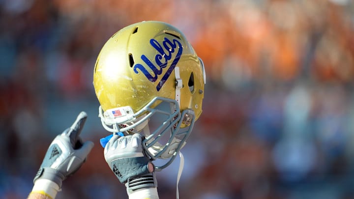 Sept 25, 2010; Austin, TX, USA; A member of the UCLA Bruins holds up his helmet to acknowledge their fans against the Texas Longhorns during the fourth quarter at Texas Memorial Stadium. UCLA beat Texas 34-12. Mandatory Credit: Brendan Maloney-Imagn Images