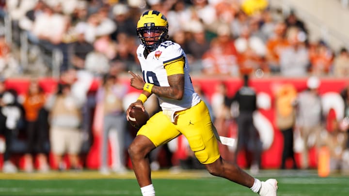 Dec 31, 2025; Orlando, FL, USA; Michigan Wolverines quarterback Bryce Underwood (19) looks to throw on the run against the Texas Longhorns during the first half at Camping World Stadium. Mandatory Credit: Matt Pendleton-Imagn Images