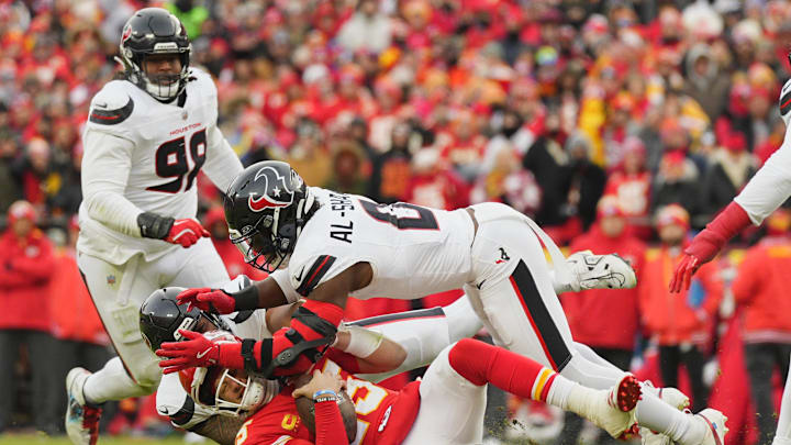 Jan 18, 2025; Kansas City, Missouri, USA; Kansas City Chiefs quarterback Patrick Mahomes (15) is sacked by Houston Texans linebacker Azeez Al-Shaair (top) and defensive tackle Tommy Togiai (72) during the first quarter of a 2025 AFC divisional round game at GEHA Field at Arrowhead Stadium. Mandatory Credit: Jay Biggerstaff-Imagn Images