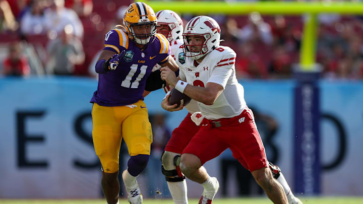 Wisconsin quarterback Tanner Mordecai (8) runs with the ball chased by LSU linebacker Jaxon Howard (11) in the fourth quarter during the ReliaQuest Bowl at Raymond James Stadium in Tampa, Fla., on Jan. 1, 2024.