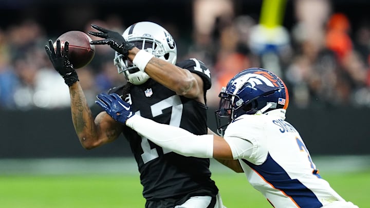 Jan 7, 2024; Paradise, Nevada, USA; Las Vegas Raiders wide receiver Davante Adams (17) makes a catch against Denver Broncos cornerback Pat Surtain II (2) during the second quarter at Allegiant Stadium.