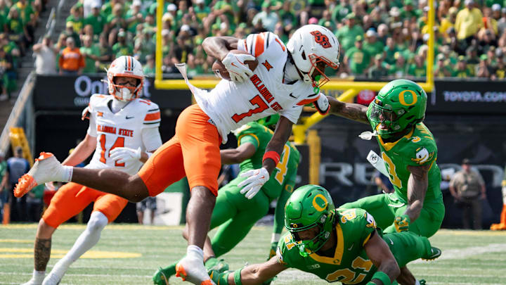 Oregon defensive backs Sione Laulea, right, and Aaron Flowers trip up Oklahoma State wide receiver Shamar Rigby as the Oregon Ducks host the Oklahoma State Cowboys on Sept. 6, 2025, at Autzen Stadium in Eugene, Oregon. Oregon defensive backs Sione Laulea, right, and Aaron Flowers trip up Oklahoma State wide receiver Shamar Rigby as the Oregon Ducks host the Oklahoma State Cowboys on Sept. 6, 2025, at Autzen Stadium in Eugene, Oregon.