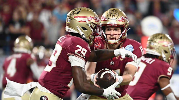 Dec 2, 2023; Charlotte, NC, USA; Florida State Seminoles quarterback Brock Glenn (11) hands off the ball to running back Rodney Hill (29) in the first quarter against the Louisville Cardinals at Bank of America Stadium. Mandatory Credit: Bob Donnan-Imagn Images