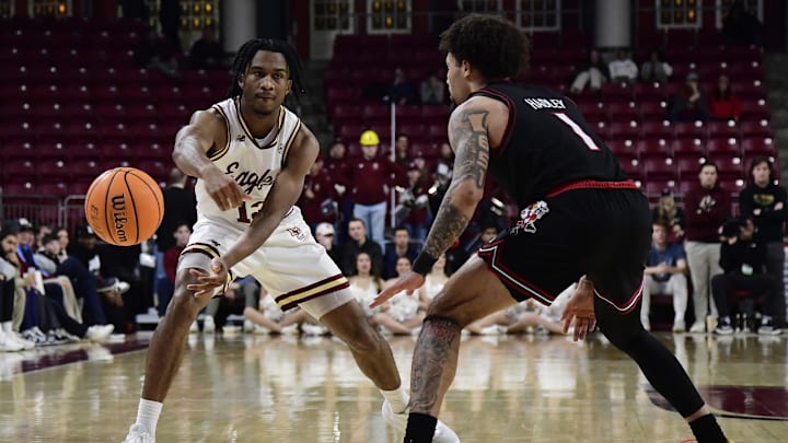 Feb 5, 2025; Chestnut Hill, Massachusetts, USA;  Boston College Eagles guard Donald Hand Jr. (13) passes the ball past Louisville Cardinals guard J'Vonne Hadley (1) during the second half at Conte Forum. Mandatory Credit: Bob DeChiara-Imagn Images