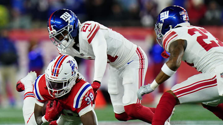 Dec 1, 2025; Foxborough, Massachusetts, USA; New England Patriots running back Rhamondre Stevenson (38) carries the ball against New York Giants cornerback Paulson Adebo (21) during the second quarter at Gillette Stadium.  