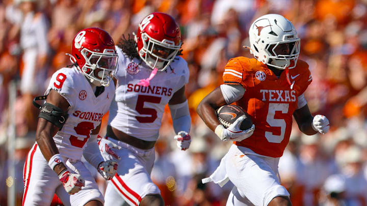 Texas Longhorns running back Quintrevion Wisner (5) runs past Oklahoma Sooners defensive back Gentry Williams (9) and linebacker Kendal Daniels (5) during the first half at the Cotton Bowl. 