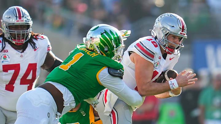 Ohio State Buckeyes quarterback Will Howard (18) runs through Oregon Ducks defensive end Jordan Burch (1) during the first half of the College Football Playoff quarterfinal at the Rose Bowl in Pasadena, Calif. on Jan. 1, 2025.