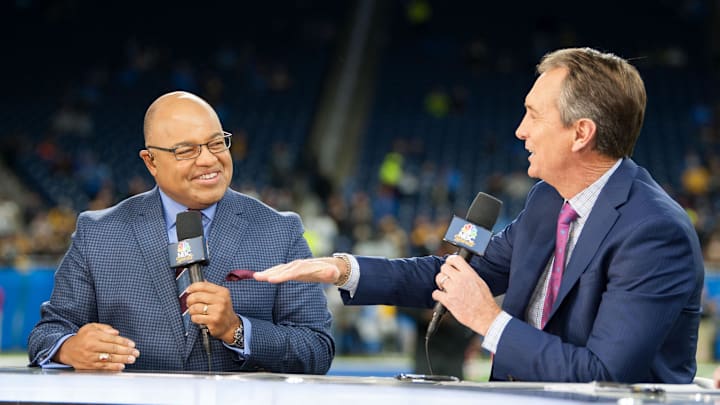Broadcasters Mike Tirico and Cris Collinsworth speak before a game. Broadcasters Mike Tirico and Cris Collinsworth speak before a game.