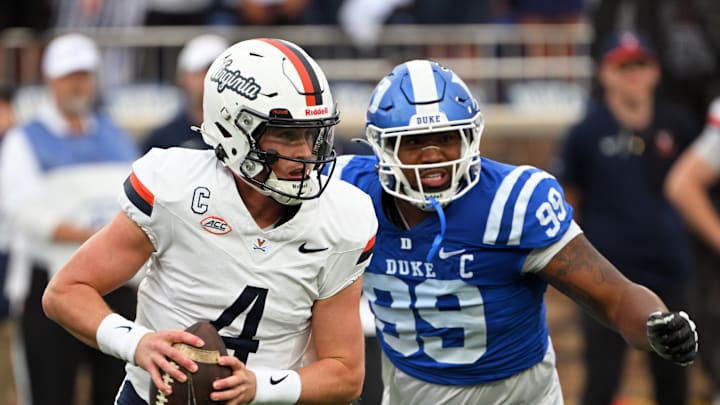 Nov 15, 2025; Durham, North Carolina, USA;  Virginia Cavaliers quarter back Chandler Morris (4) looks for an opening against Duke Blue Devils defensive tackle Aaron Hall (99) during the first quarter at Wallace Wade Stadium. Mandatory Credit: Zachary Taft-Imagn Images