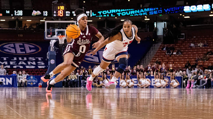 Mar 6, 2025; Greenville, SC, USA; Mississippi State Bulldogs guard Denim DeShields (0) drives by Ole Miss Rebels guard KK Deans (1) during the first half at Bon Secours Wellness Arena. Mandatory Credit: Scott Kinser-Imagn Images