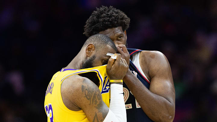 Nov 27, 2023; Philadelphia, Pennsylvania, USA; Philadelphia 76ers center Joel Embiid (21) talks with Los Angeles Lakers forward LeBron James (23) during the second quarter at Wells Fargo Center. Mandatory Credit: Bill Streicher-Imagn Images