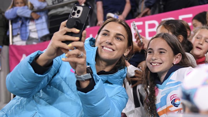 May 8, 2024; San Diego, California, USA; San Diego Wave FC forward Alex Morgan (13) takes a selfie with fans following the victory against Utah Royals FC at Snapdragon Stadium. May 8, 2024; San Diego, California, USA; San Diego Wave FC forward Alex Morgan (13) takes a selfie with fans following the victory against Utah Royals FC at Snapdragon Stadium.
