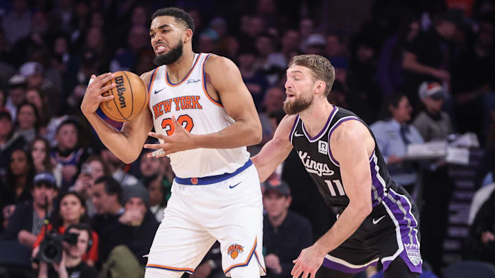 Jan 25, 2025; New York, New York, USA;  New York Knicks center Karl-Anthony Towns (32) secures the ball against Sacramento Kings forward Domantas Sabonis (11) in the third quarter at Madison Square Garden. Mandatory Credit: Wendell Cruz-Imagn Images