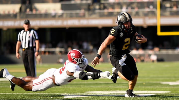 Oct 5, 2024; Nashville, Tennessee, USA;  Vanderbilt Commodores quarterback Diego Pavia (2) breaks the tackle of Alabama Crimson Tide defensive lineman LT Overton (22) during the first half at FirstBank Stadium. Mandatory Credit: Steve Roberts-Imagn Images