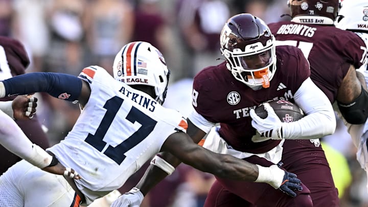 Sep 27, 2025; College Station, Texas, USA; Texas A&M Aggies running back Le'Veon Moss (8) runs the ball as Auburn Tigers linebacker Xavier Atkins (17) lunges for the tackle during the third quarter at Kyle Field. Mandatory Credit: Maria Lysaker-Imagn Images 