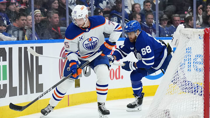Dec 13, 2025; Toronto, Ontario, CAN; Toronto Maple Leafs right wing William Nylander (88) battles for the puck behind the net with Edmonton Oilers defenseman Alec Regula (75) during the third period at Scotiabank Arena. Mandatory Credit: Nick Turchiaro-Imagn Images