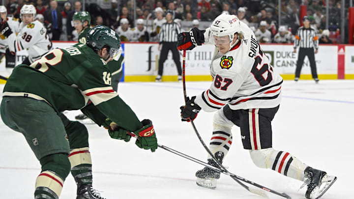 Sep 30, 2023; Saint Paul, Minnesota, USA; Minnesota Wild forward Sammy Walker (18) pokes the puck away from Chicago Blackhawks forward Samuel Savoie (67) during the second period at Xcel Energy Center. Mandatory Credit: Nick Wosika-Imagn Images

