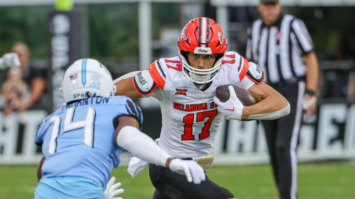 Nov 11, 2023; Orlando, Florida, USA; Oklahoma State Cowboys wide receiver Leon Johnson III (17) runs the ball against UCF Knights defensive back Corey Thornton (14) during the first quarter at FBC Mortgage Stadium. Mandatory Credit: Mike Watters-USA TODAY Sports