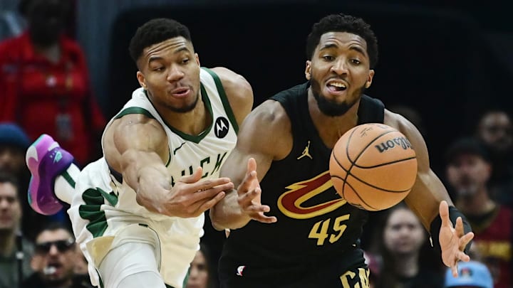 Dec 29, 2023; Cleveland, Ohio, USA; Milwaukee Bucks forward Giannis Antetokounmpo (34) and Cleveland Cavaliers guard Donovan Mitchell (45) go for a loose ball during the first half at Rocket Mortgage FieldHouse. Mandatory Credit: Ken Blaze-Imagn Images