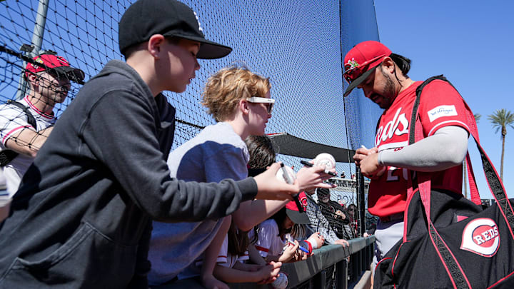 Cincinnati Reds third baseman Eugenio Suárez (28) signs baseballs for fans ahead of a Cactus League game against the Cleveland Guardians, Saturday, Feb. 21, 2026, at Goodyear Ballpark in Goodyear, Ariz.