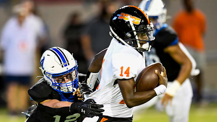 Hoover's Jonah Winston (14) tries to shake the tackle of Auburn High School's Coleman Granberry (12) during their game at Cramton Bowl in Montgomery, Ala., on Friday evening August 19, 2022.