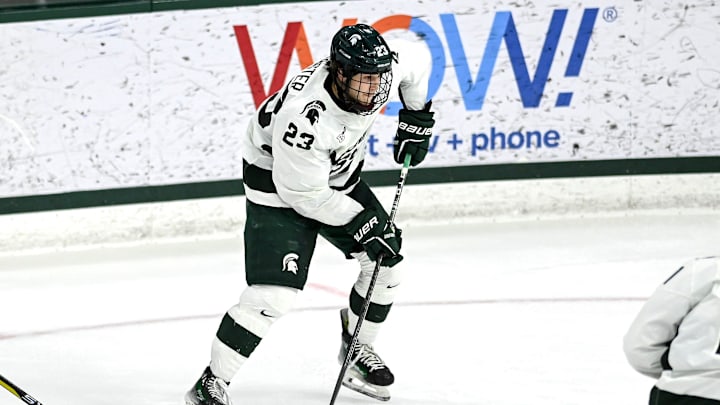 Michigan State's Reed Lebster takes a shot at Michigan's goalie during the third period on Friday,