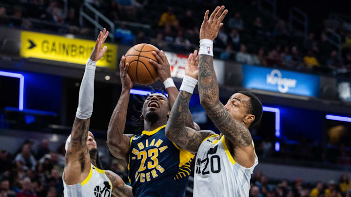 Nov 8, 2023; Indianapolis, Indiana, USA; Indiana Pacers forward Aaron Nesmith (23) shoots the ball while Utah Jazz guard Jordan Clarkson (00) and forward John Collins (20) defend in the second half at Gainbridge Fieldhouse. Mandatory Credit: Trevor Ruszkowski-Imagn Images