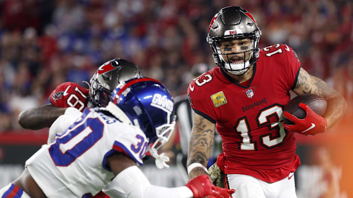 Nov 22, 2021; Tampa, Florida, USA;  Tampa Bay Buccaneers wide receiver Mike Evans (13) runs with the ball as New York Giants cornerback Darnay Holmes (30) defends during the first quarter at Raymond James Stadium. Mandatory Credit: Kim Klement-Imagn Images