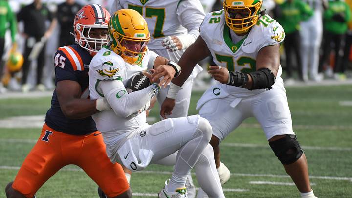 Oct 24, 2026; Champaign, Illinois, USA; Illinois Fighting Illini linebacker Robert Edmonson (45) tackles Oregon Ducks quarterback Dylan Raiola (8) during the first half at Gies Memorial Stadium. Mandatory Credit: Ron Johnson-Imagn Images Oct 24, 2026; Champaign, Illinois, USA; Illinois Fighting Illini linebacker Robert Edmonson (45) tackles Oregon Ducks quarterback Dylan Raiola (8) during the first half at Gies Memorial Stadium. Mandatory Credit: Ron Johnson-Imagn Images
