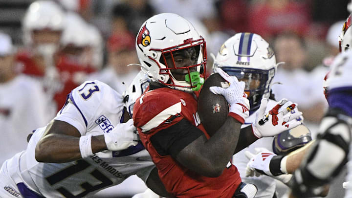 Sep 5, 2025; Louisville, Kentucky, USA; Louisville Cardinals running back Isaac Brown (1) runs the ball against James Madison Dukes safety Tyler Brown (13) during the first half at L&N Federal Credit Union Stadium. Mandatory Credit: Jamie Rhodes-Imagn Images Sep 5, 2025; Louisville, Kentucky, USA; Louisville Cardinals running back Isaac Brown (1) runs the ball against James Madison Dukes safety Tyler Brown (13) during the first half at L&N Federal Credit Union Stadium. Mandatory Credit: Jamie Rhodes-Imagn Images