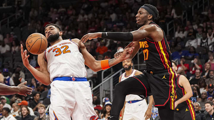 Apr 5, 2025; Atlanta, Georgia, USA; New York Knicks center Karl-Anthony Towns (32) catches a rebound against Atlanta Hawks forward Onyeka Okongwu (17) during the second half at State Farm Arena. Mandatory Credit: Dale Zanine-Imagn Images