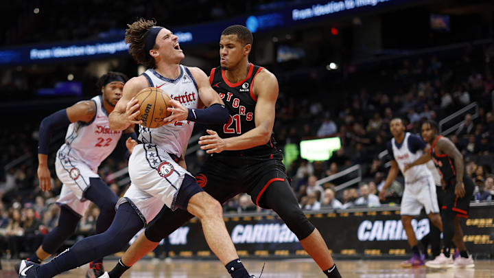 Jan 29, 2025; Washington, District of Columbia, USA; Washington Wizards forward Corey Kispert (24) drives to the basket as Toronto Raptors center Orlando Robinson (21) defends in the second quarter at Capital One Arena. Mandatory Credit: Geoff Burke-Imagn Images