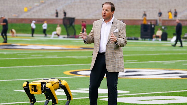 Sep 14, 2024; Columbia, Missouri, USA; Missouri Tigers head coach Eli Drinkwitz is interviewed on field with the College of Engineering’s Boston robotics robot Spot on field prior to a game against the Boston College Eagles at Faurot Field at Memorial Stadium. Mandatory Credit: Denny Medley-Imagn Images Sep 14, 2024; Columbia, Missouri, USA; Missouri Tigers head coach Eli Drinkwitz is interviewed on field with the College of Engineering’s Boston robotics robot Spot on field prior to a game against the Boston College Eagles at Faurot Field at Memorial Stadium. Mandatory Credit: Denny Medley-Imagn Images