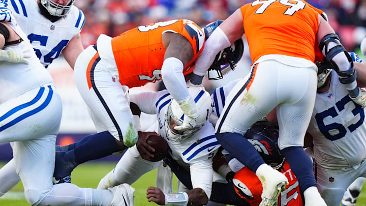 Dec 15, 2024; Denver, Colorado, USA; Denver Broncos defensive end John Franklin-Myers (98) and linebacker Nik Bonitto (15) tackle Indianapolis Colts quarterback Anthony Richardson (5) in the first half at Empower Field at Mile High. Mandatory Credit: Ron Chenoy-Imagn Images