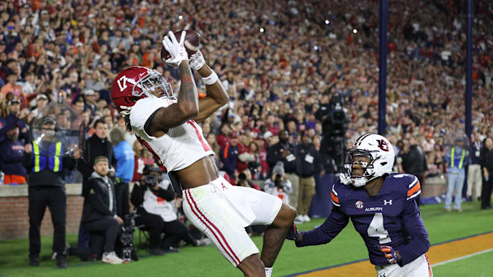 Nov 25, 2023; Auburn, Alabama, USA;  Alabama Crimson Tide wide receiver Isaiah Bond (17) scores the game winning touchdown over Auburn Tigers cornerback D.J. James (4) during the fourth quarter at Jordan-Hare Stadium. Mandatory Credit: John Reed-Imagn Images