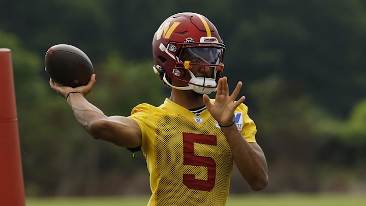 Jul 23, 2025; Ashburn, VA, USA; Washington Commanders quarterback Jayden Daniels (5) passes a ball during practice on day one of training camp at OrthoVirginia Training Center at Commanders Park. Mandatory Credit: Geoff Burke-Imagn Images
