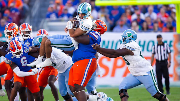 Florida Gators defensive lineman Desmond Watson (21) tackles Tulane Green Wave quarterback Ty Thompson (7) during the first half at Raymond James Stadium in Tampa, FL on Friday, December 20, 2024 in the 2024 Union Home Mortgage Gasparilla Bowl. [Doug Engle/Gainesville Sun]
