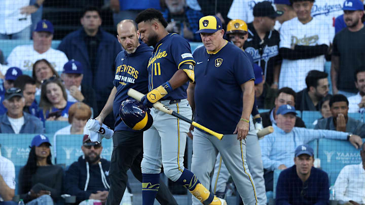 Oct 16, 2025; Los Angeles, California, USA; Milwaukee Brewers center fielder Jackson Chourio (11) is rendered aid by medical staff in the seventh inning during game three of the NLCS round for the 2025 MLB playoffs at Dodger Stadium.  Mandatory Credit: Kiyoshi Mio-Imagn Images
