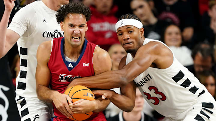 Illinois-Chicago Flames guard Isaiah Rivera (1) and Cincinnati Bearcats forward Ody Oguama (33)