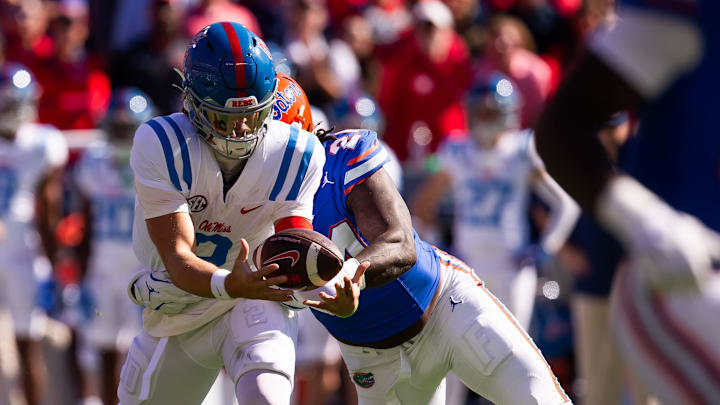 Mississippi quarterback Jaxson Dart (2) bobbles the ball as Florida defender Kamran James (24) tackles him during the first half at Ben Hill Griffin Stadium in Gainesville, Fla., on Saturday, Nov. 23, 2024. Mississippi quarterback Jaxson Dart (2) bobbles the ball as Florida defender Kamran James (24) tackles him during the first half at Ben Hill Griffin Stadium in Gainesville, Fla., on Saturday, Nov. 23, 2024.