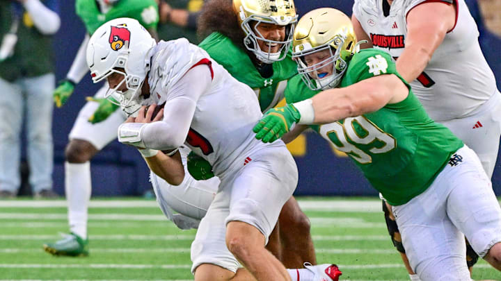 Sep 28, 2024; South Bend, Indiana, USA; Notre Dame Fighting Irish defensive lineman Rylie Mills (99) sacks Louisville Cardinals quarterback Tyler Shough (9) in the fourth quarter at Notre Dame Stadium. Mandatory Credit: Matt Cashore-Imagn Images