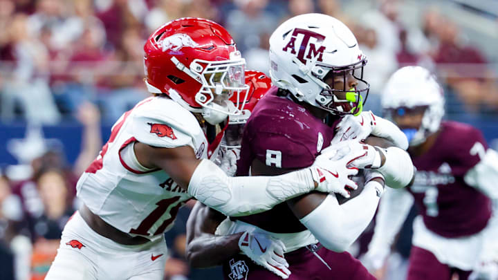 Sep 28, 2024; Arlington, Texas, USA;  Texas A&M Aggies running back Le'Veon Moss (8) runs with the ball as Arkansas Razorbacks defensive back TJ Metcalf (18) defends during the second half at AT&T Stadium. Mandatory Credit: Kevin Jairaj-Imagn Images