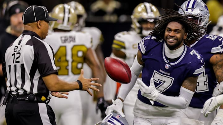 Dallas Cowboys cornerback Trevon Diggs laughed as he hands the ball to back judge Greg Steed after losing his helmet.