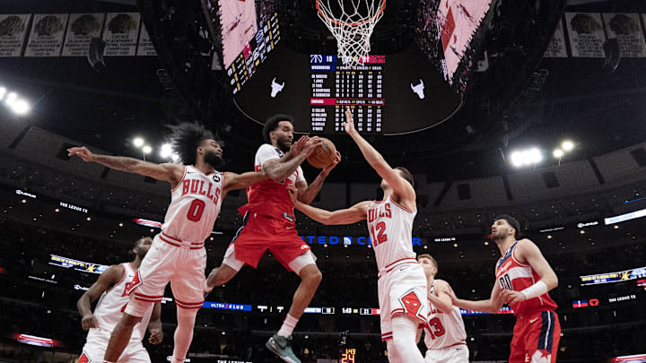 Apr 11, 2025; Chicago, Illinois, USA; Chicago Bulls guard Coby White (0) defends Washington Wizards forward Justin Champagnie (9) during the first quarter at United Center. Mandatory Credit: David Banks-Imagn Images