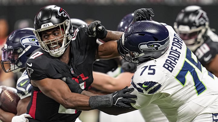 Dec 7, 2025; Atlanta, Georgia, USA; Atlanta Falcons linebacker Devine Deablo (0) and Seattle Seahawks guard Anthony Bradford (75) battle during the game at Mercedes-Benz Stadium. Mandatory Credit: Dale Zanine-Imagn Images